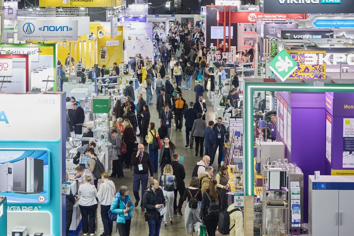 Overview of the exhibition hall with visitors among laboratory equipment stands at Analitika Expo.